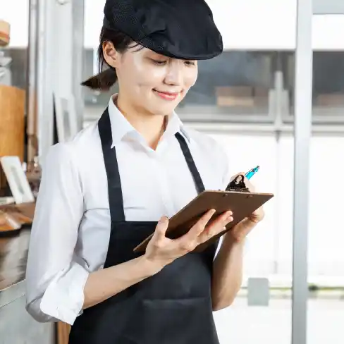 クリップボードに書き込む飲食店の女性
