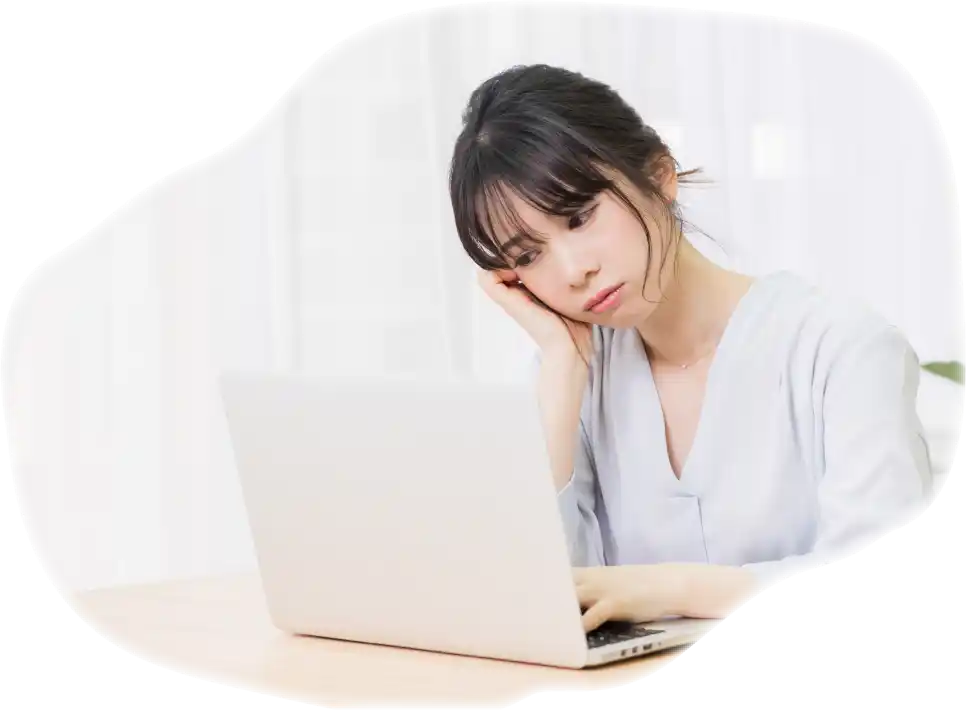 ノートPCの前で頬杖をつく女性