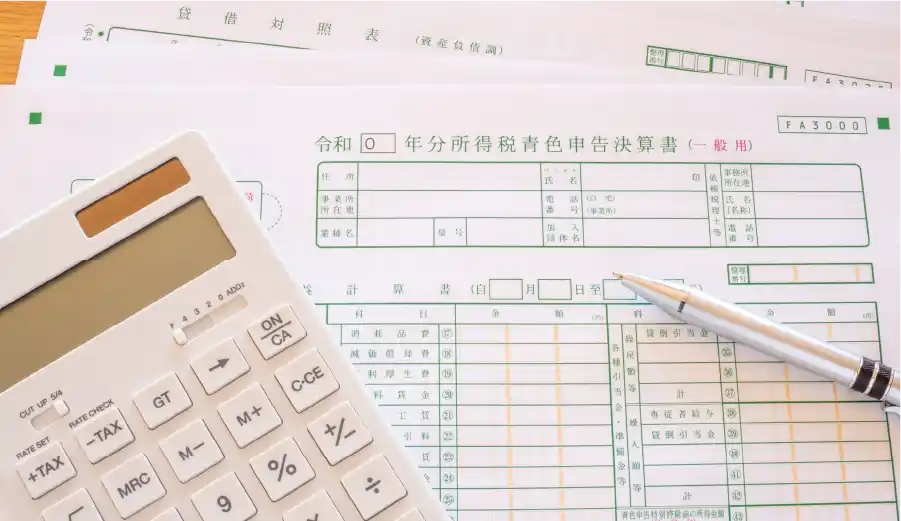青色申告決算書と電卓とペン