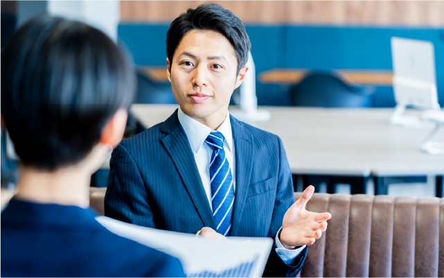 向かい合って話すスーツの男性