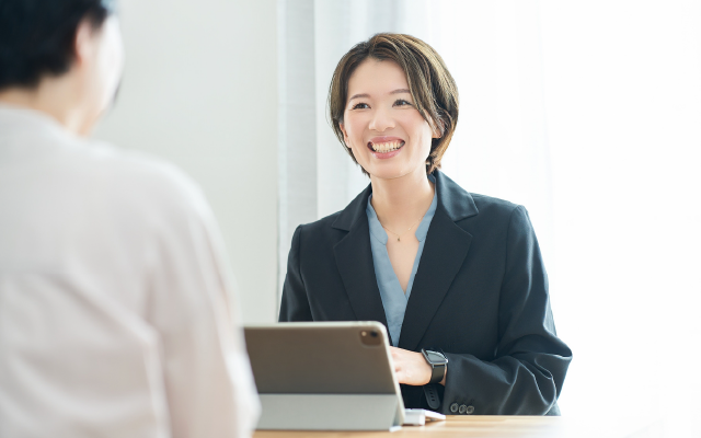 タブレットの前で笑顔の女性
